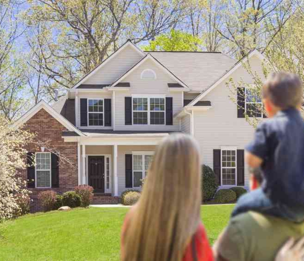 Mixed Race Young Family Looking At Beautiful New Home.
